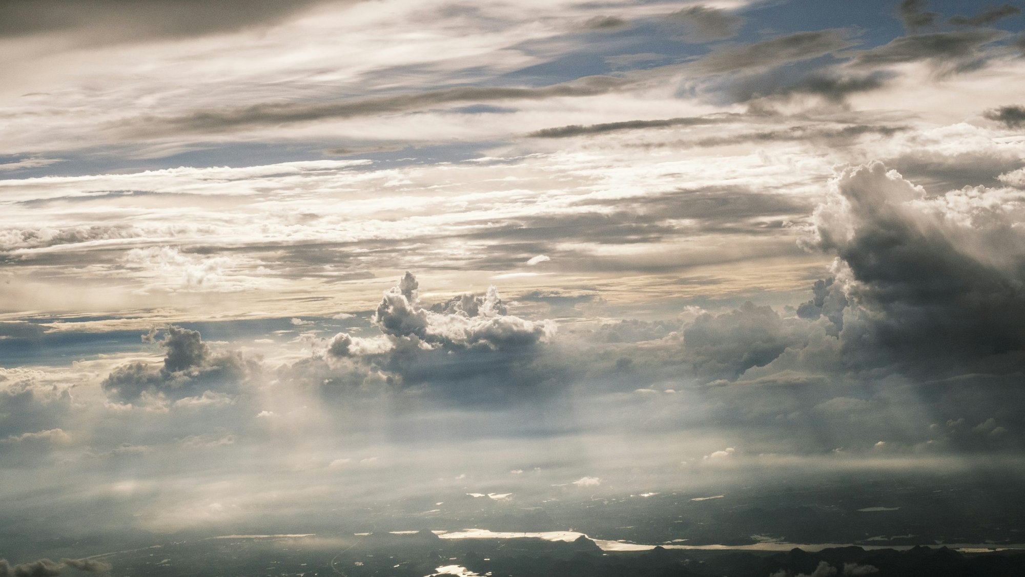 Sunlight breaking through clouds above a valley