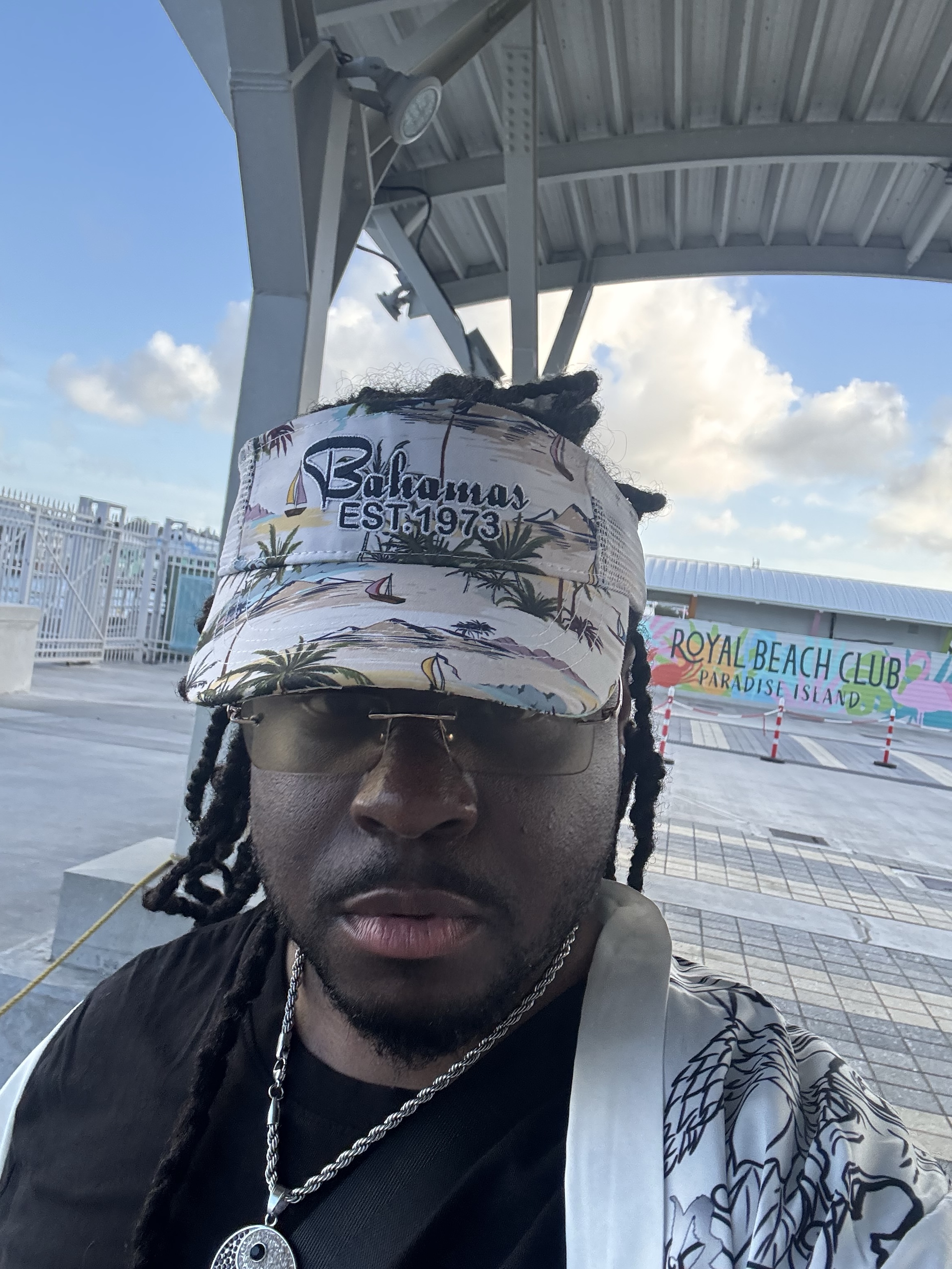 Marshall Delpé in a Bahamas visor and tinted glasses at the Royal Beach Club on Paradise Island