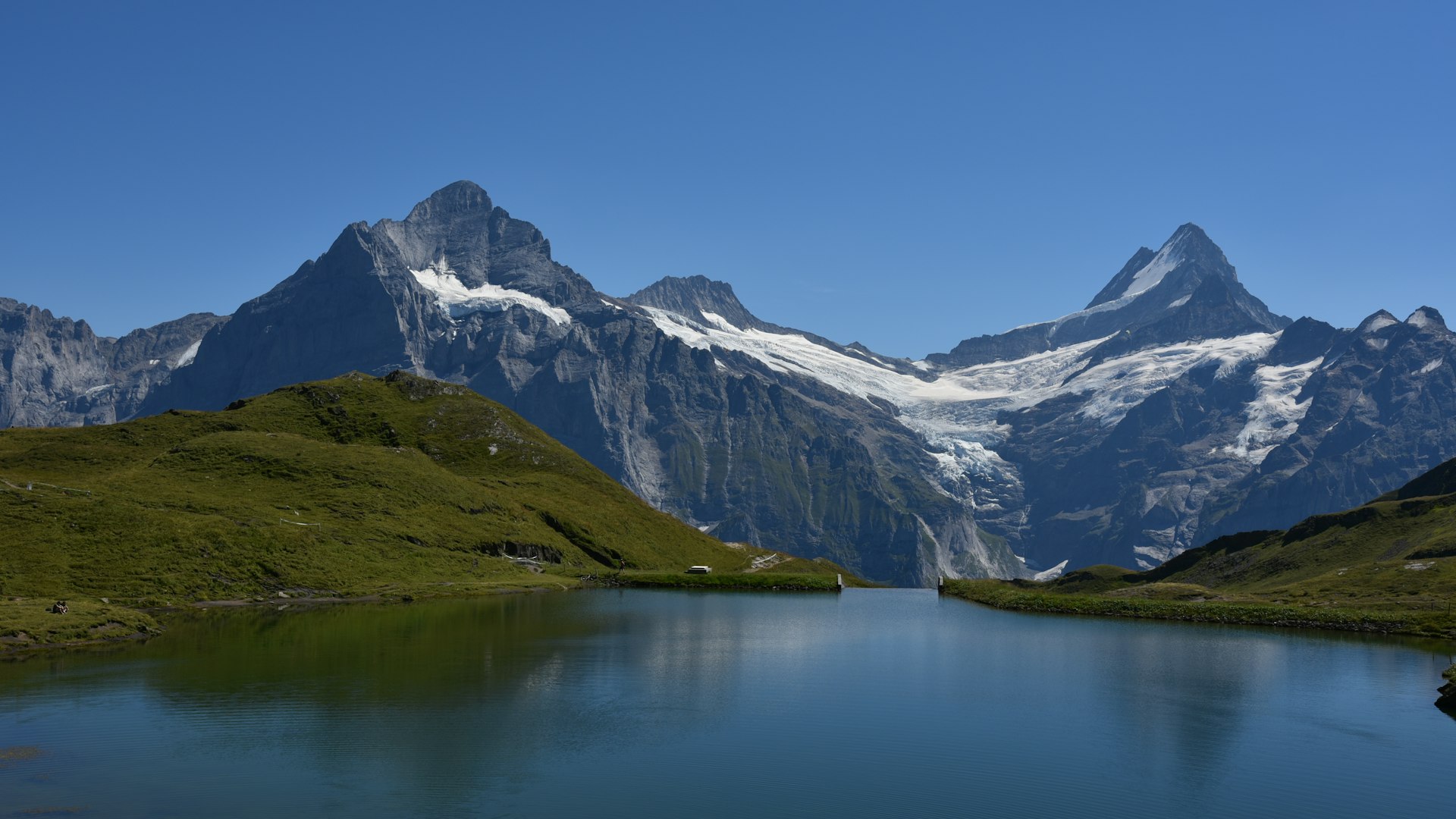 Alpine lake beneath snow-capped mountain peaks